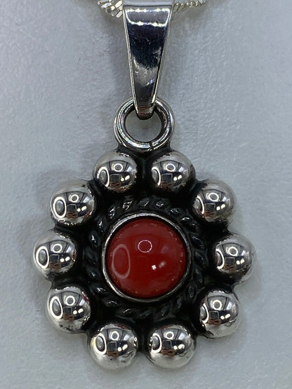 Dije de coral rojo sobre fondo blanco mostrando el Quinto 925