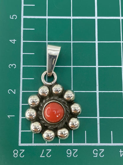 Dije de plata con coral colgando de cadena de eslabones plateados