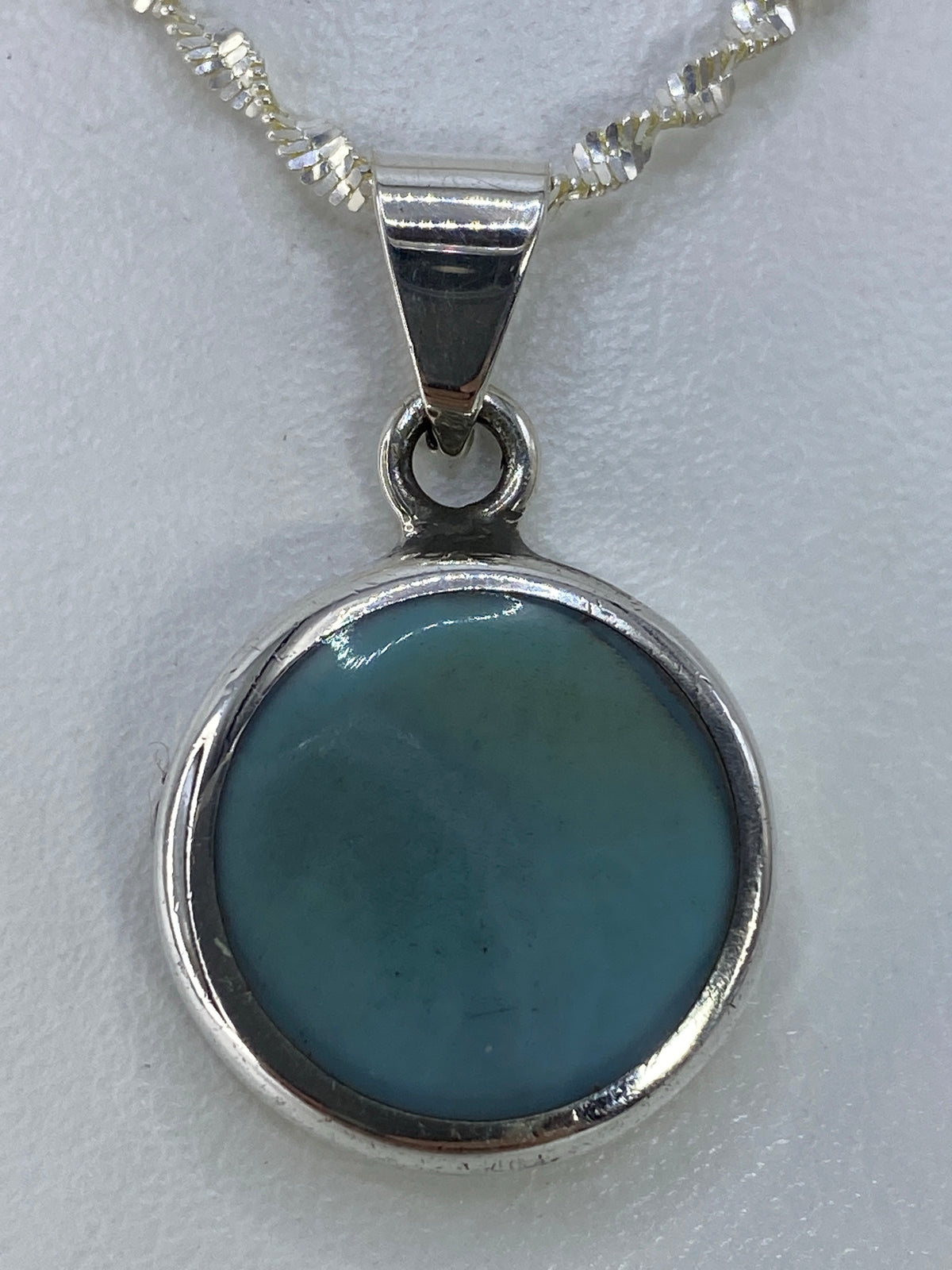 Dije de plata 925 con turquesa azul cielo engastada, 3 cm de largo, colgando de una cadena plateada