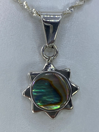 Vista frontal del dije de plata 925 con engaste a mano de piedra multicolor, sobre cadena plateada