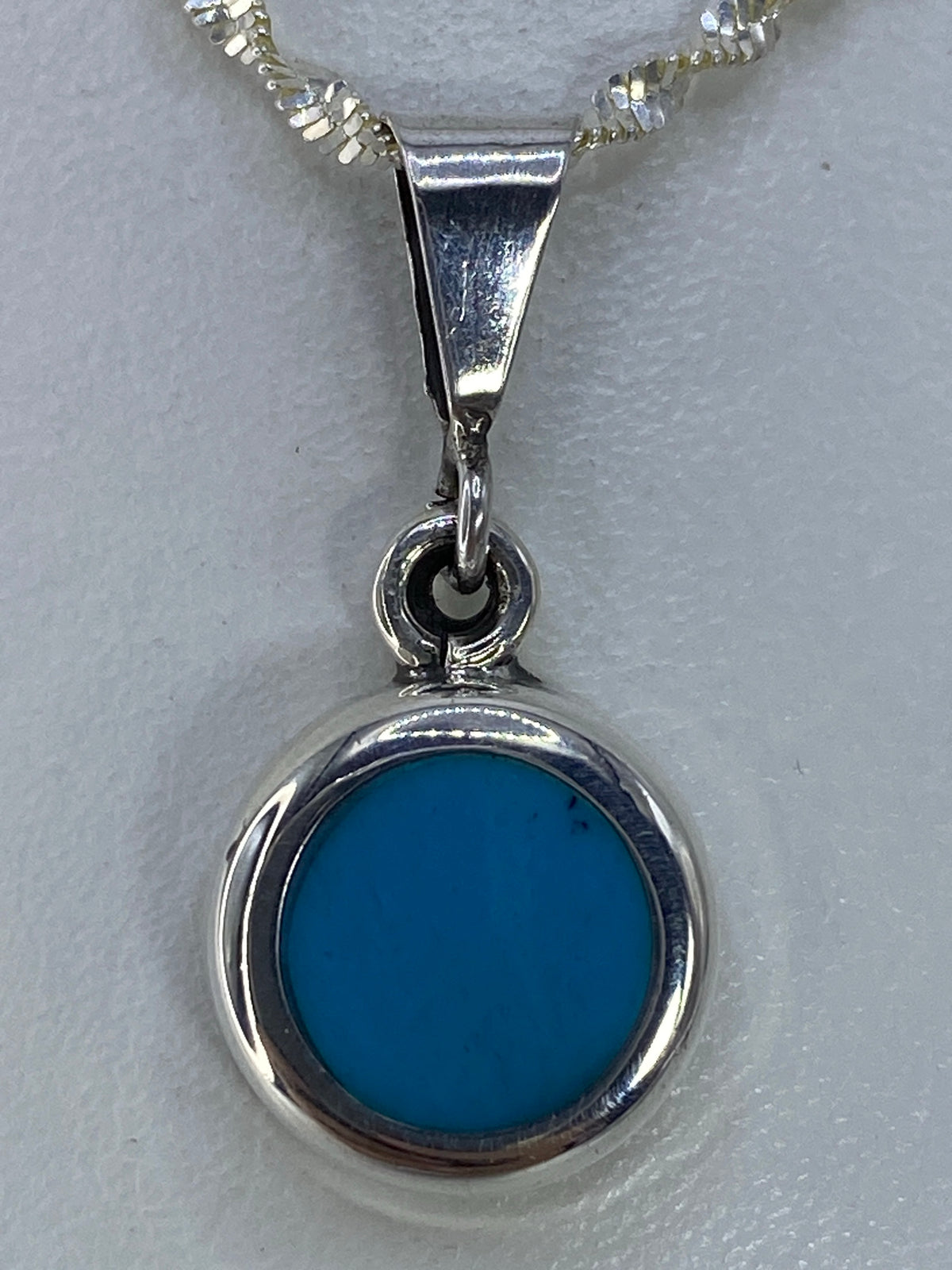 Dije circular de plata 925 con turquesa azul cielo engastada, colgando de cadena