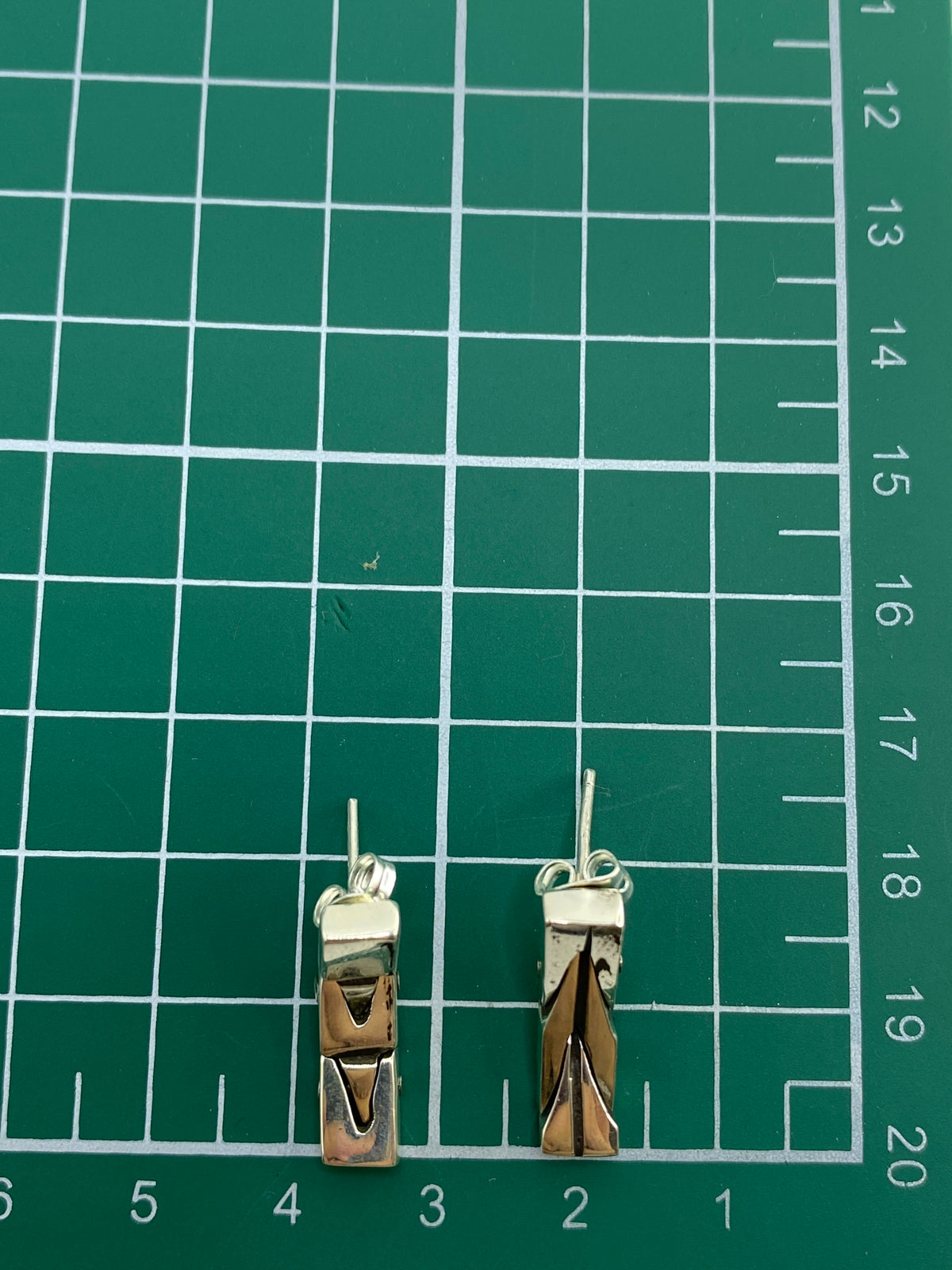 Aretes en balanza mostrando peso de 5.99 gramos