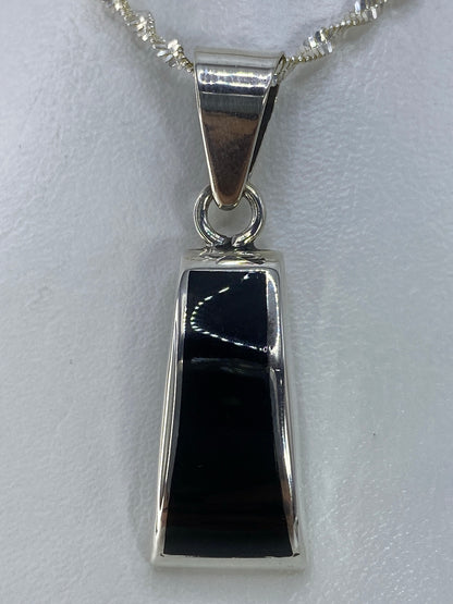 Dije de plata 925 con ónix negro engastado, colgando de cadena plateada