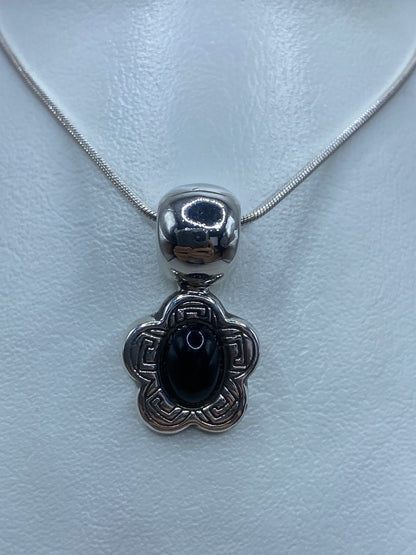 Dije de plata 925 con ónix negro en diseño prehispánico, colgando de cadena de plata