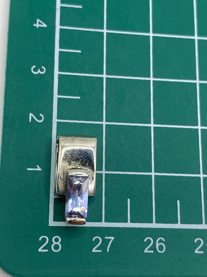 Reverso del dije mostrando el acabado de plata y el trabajo de engaste