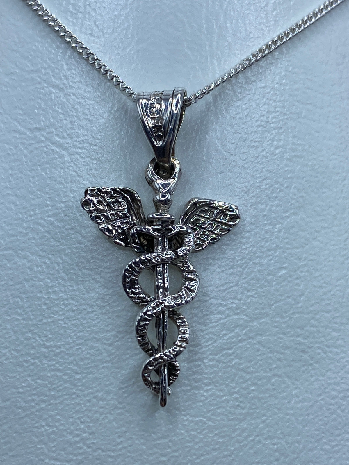 Dije caduceo de plata en escala de centímetros, 2.7 cm de largo