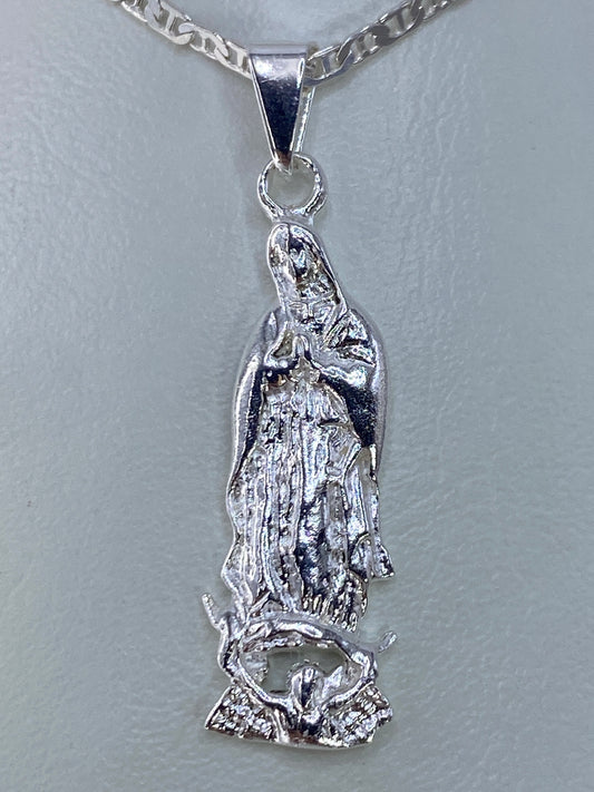 Dije de plata repujada con imagen de la Virgen María, 4 cm de largo, colgado de una cadena plateada