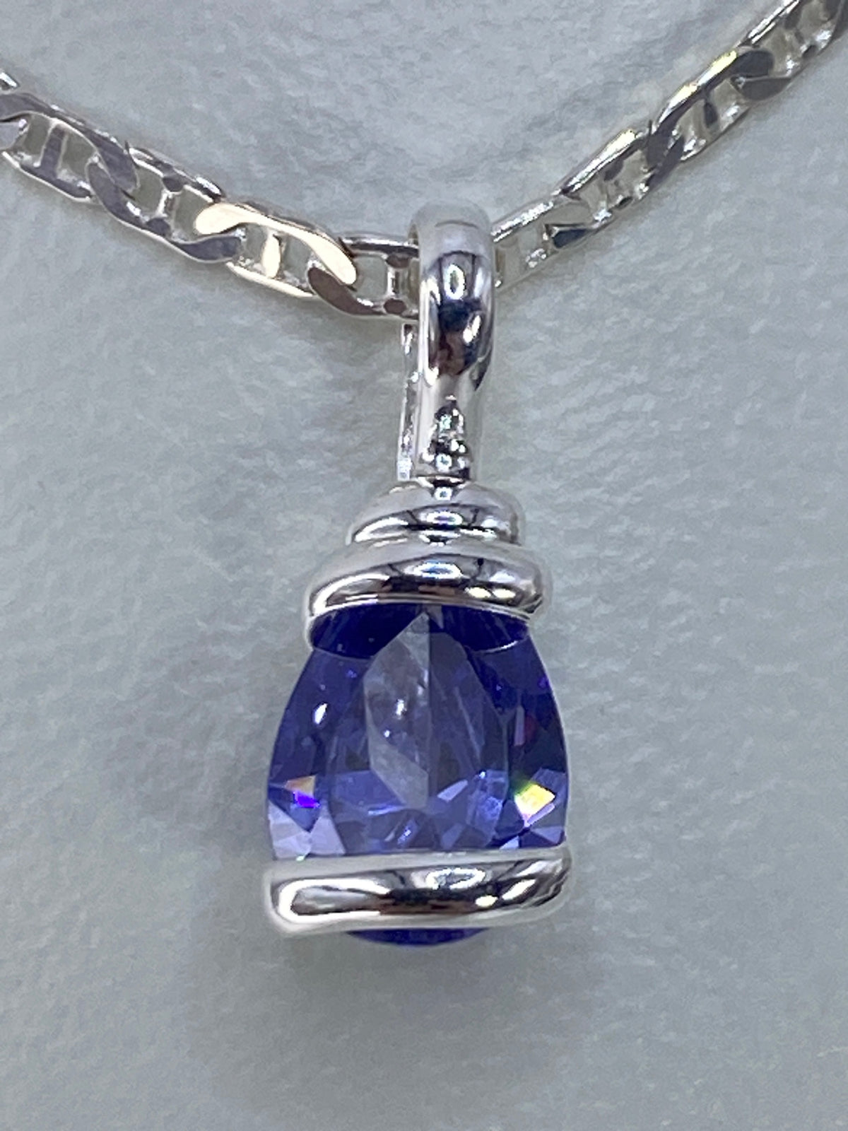 Dije de plata con circonia azul engastada sobre cadena plateada