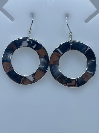 Par de aretes de plata con segmentos repujados, vistos de frente sobre fondo blanco