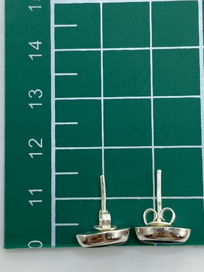 Aretes sobre escala de medida mostrando tamaño compacto