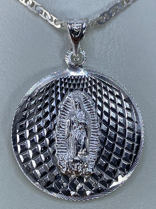 Vista frontal del dije mostrando el detalle de la Virgen de Guadalupe en relieve