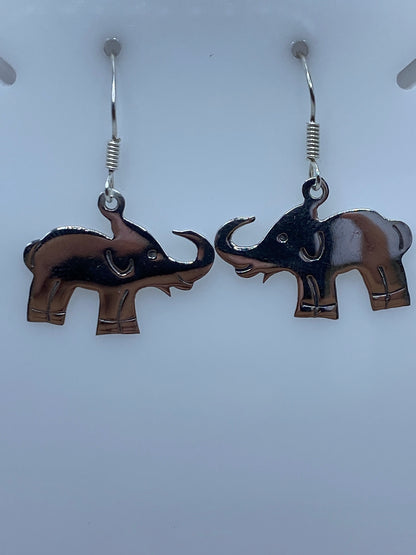 Detalle del motivo del elefante en aretes de plata fundida, mostrando el pulido y las líneas definidas
