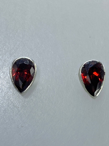 Aretes de coral rojo sobre escala de centímetros para mostrar tamaño