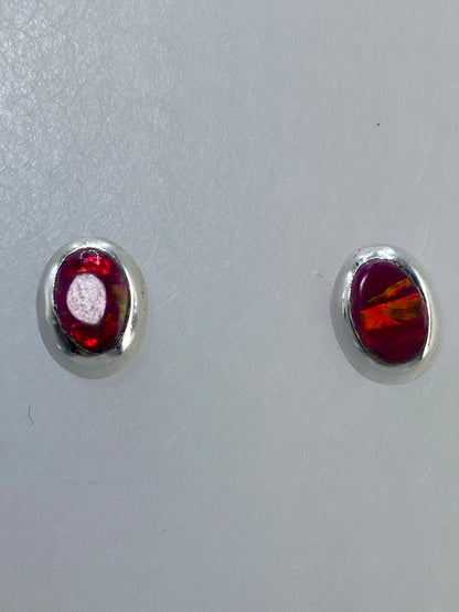 Aretes con poste y tuerca en plata, ópalo multicolor bajo luz natural