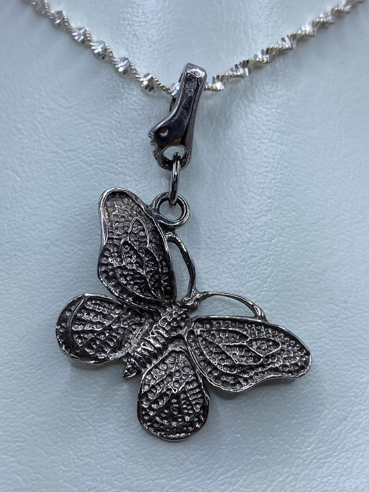 Dije de mariposa en plata 925 colgando de una cadena plateada brillo