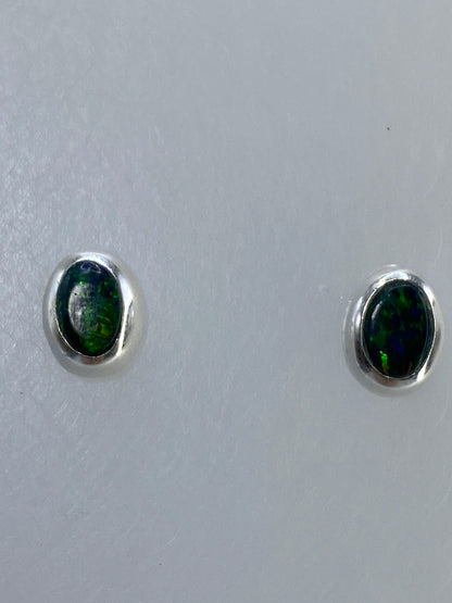 Aretes de plata junto a regla de centímetros para referencia de tamaño