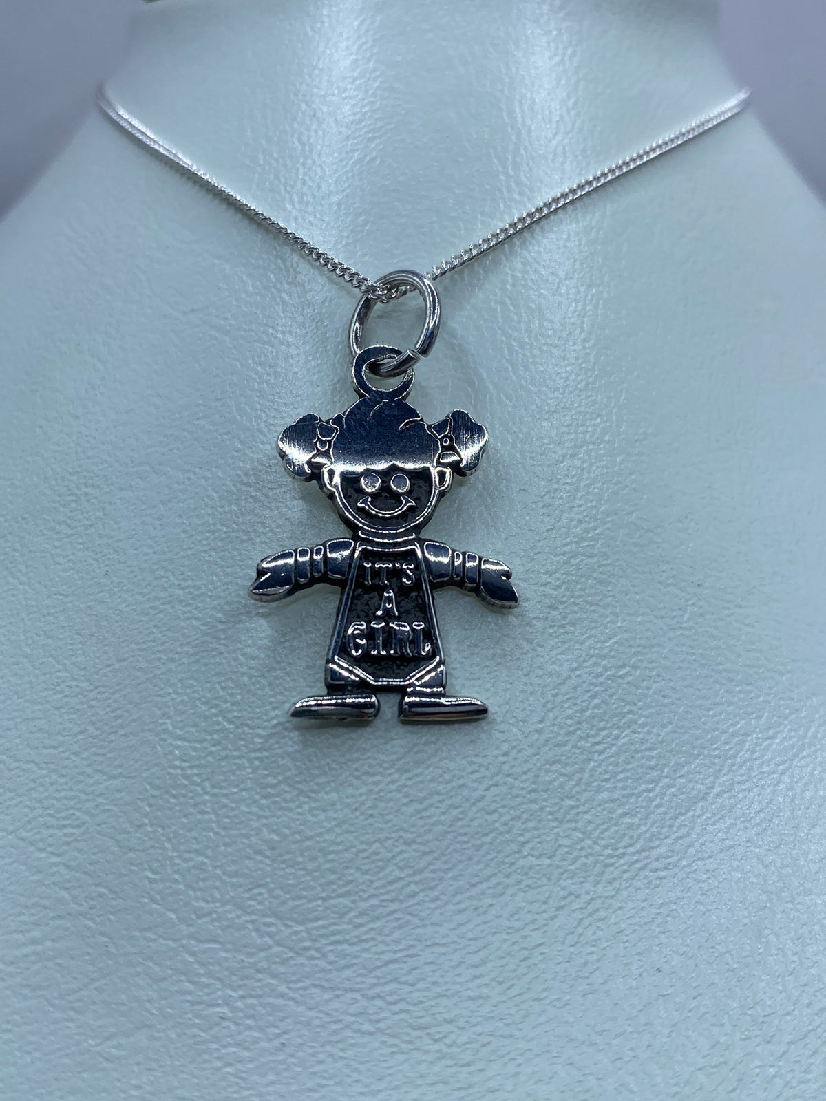 Detalle de fundición del dije infantil "It's a Girl" en plata de Taxco