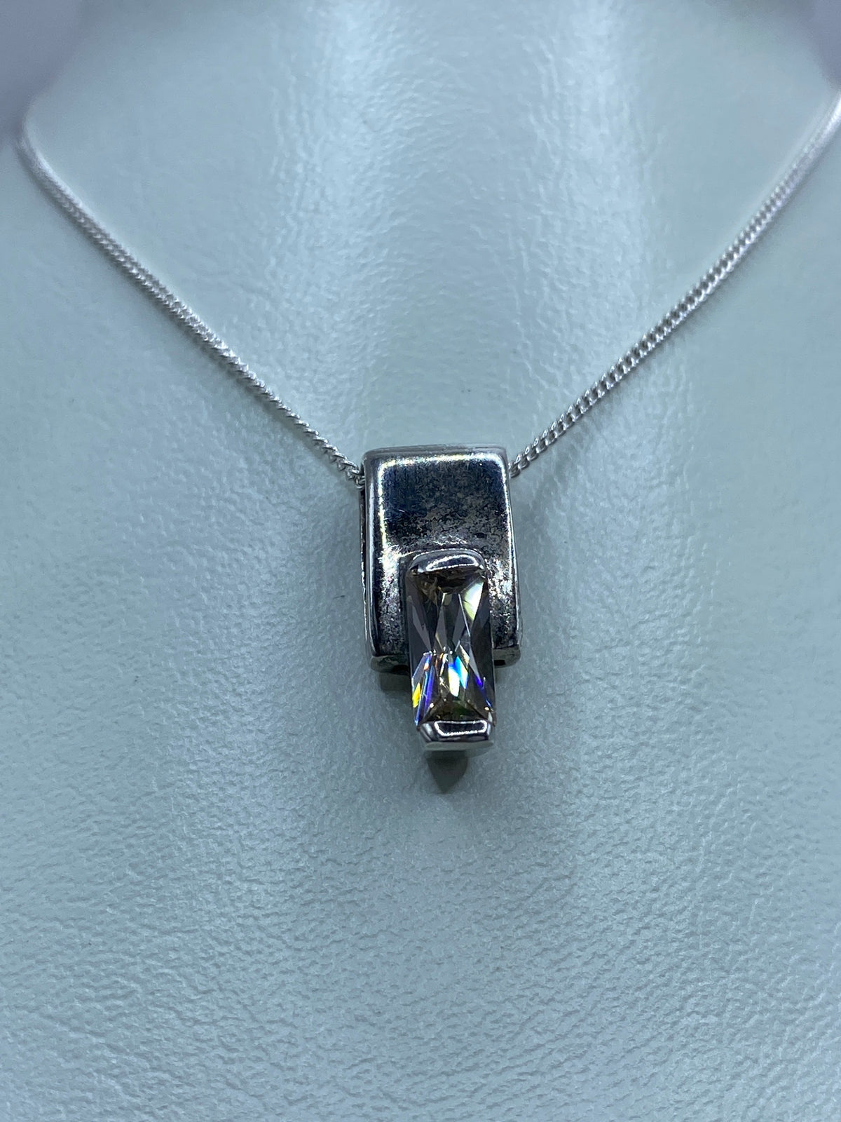 Detalle frontal del dije de plata compacto con circonia blanca brillante