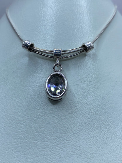 Detalle del dije de plata mostrando la circonia blanca reflejando luz
