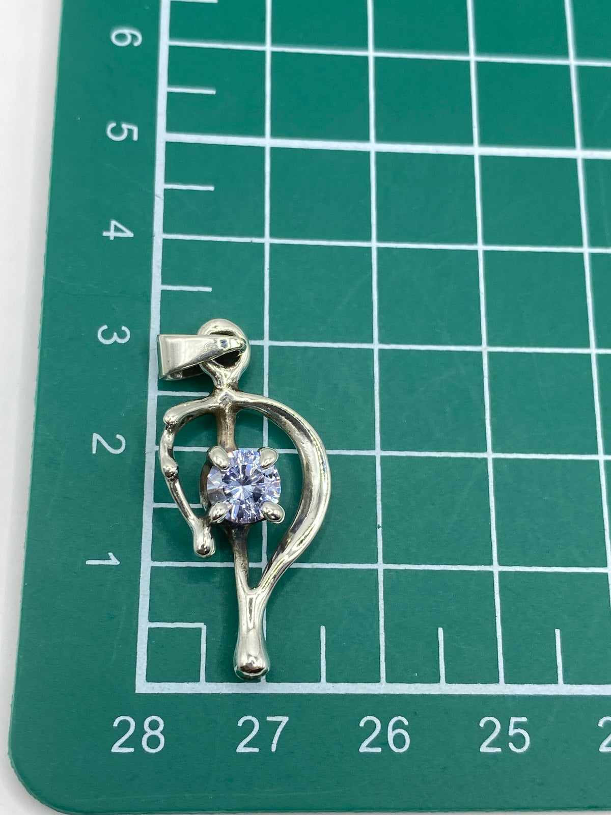 Dije de 3.6 cm sobre regla mostrando tamaño real, con sello de Quinto 925