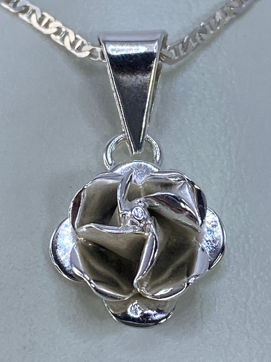 Vista frontal del dije floral en plata 925, detalles en relieve iluminados