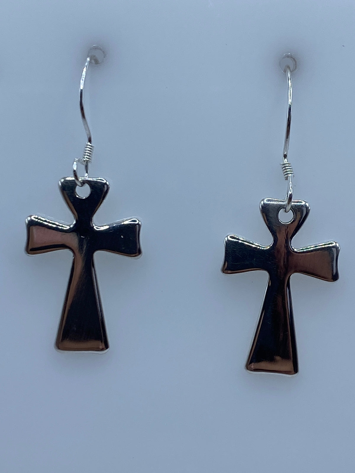 Par de aretes de cruz de plata 925 sobre fondo azul claro