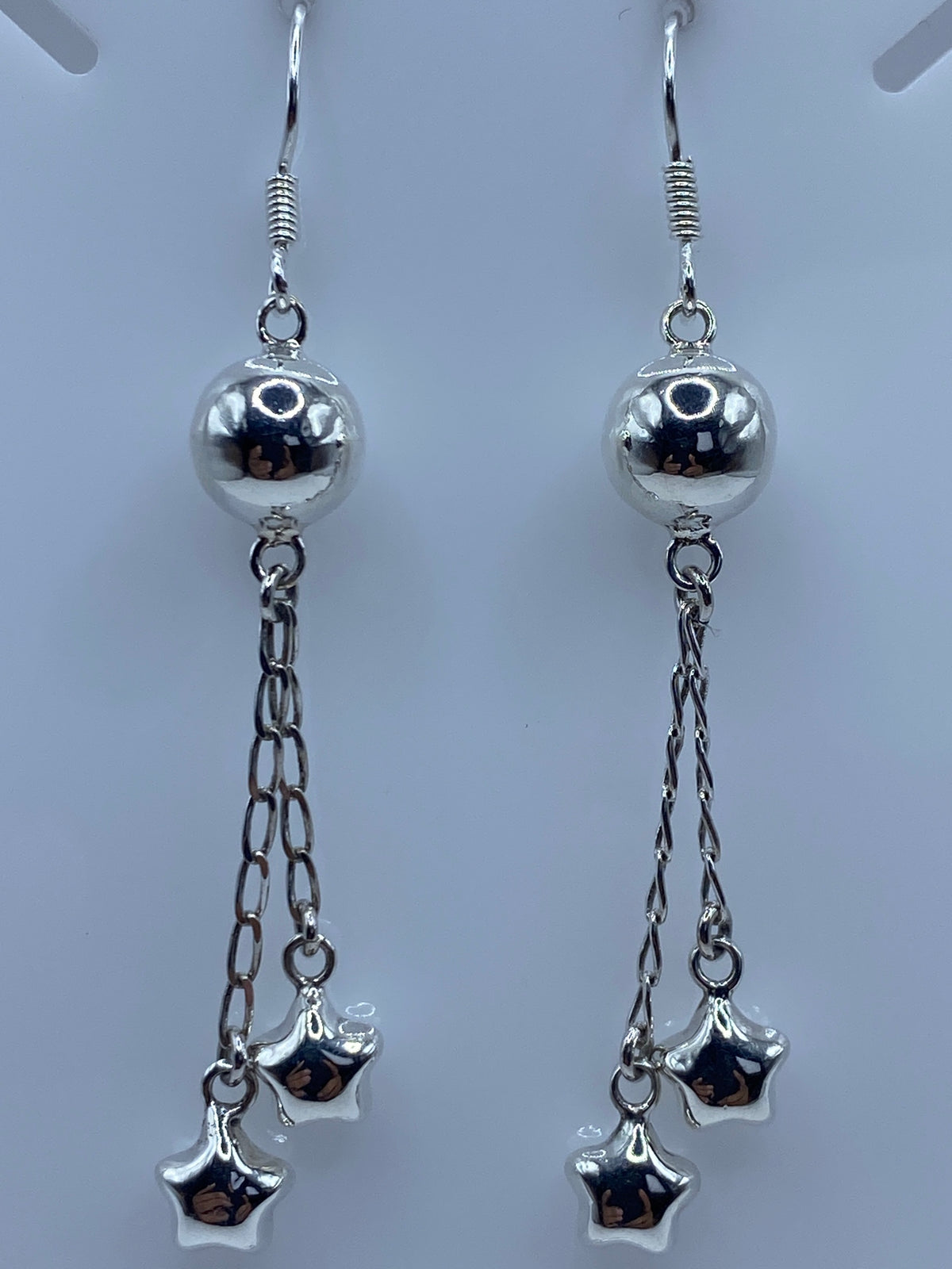 Aretes sobre regla centimetrada mostrando largo de 6.7 cm