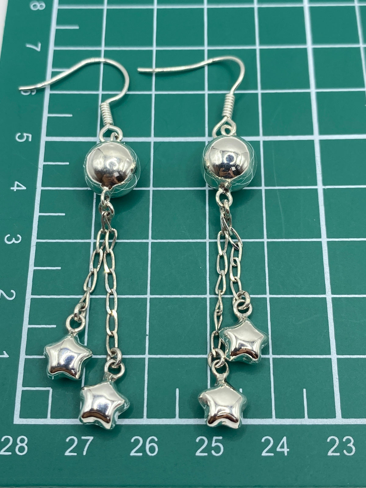 Aretes de plata pesados en escala de joyero mostrando 3.86 gramos del par