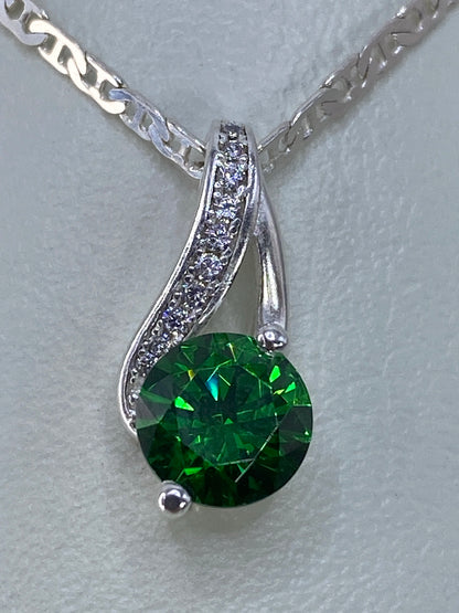 Dije de plata con circonia verde brillante, colgado en cadena de eslabón, vista frontal