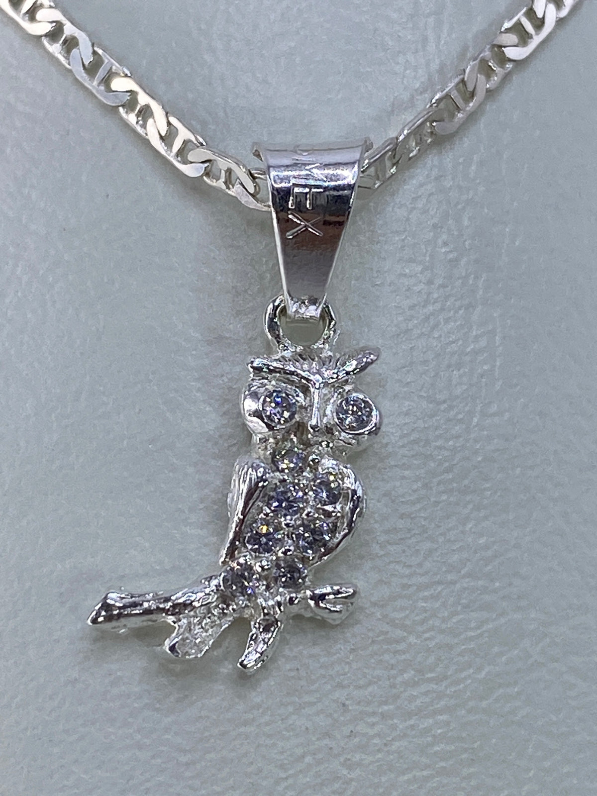 Detalle frontal del búho de plata 925 mostrando los ojos y el pecho con micro-circonia engastada