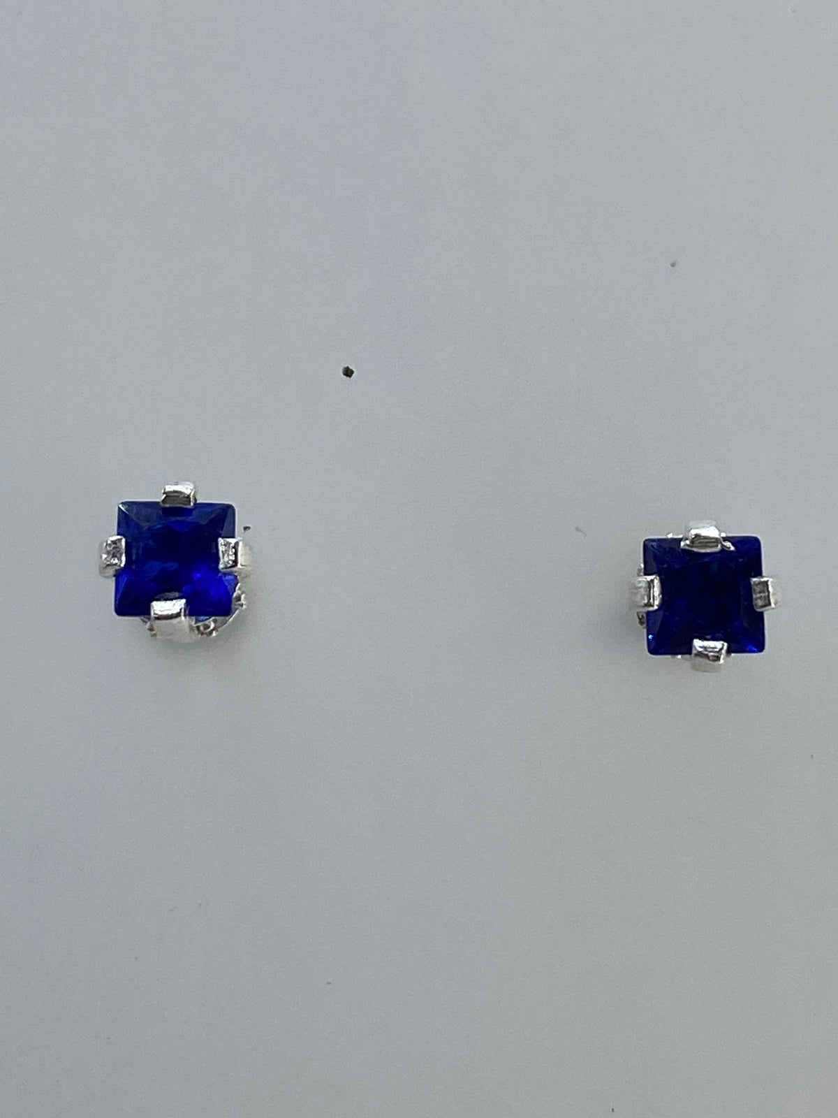 Par de aretes de plata 925 con circonia azul y micro-circonia cristalina sobre fondo blanco