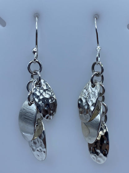 Aretes de plata 925 con eslabones combinados, acabado pulido y martillado, colgando sobre fondo gris
