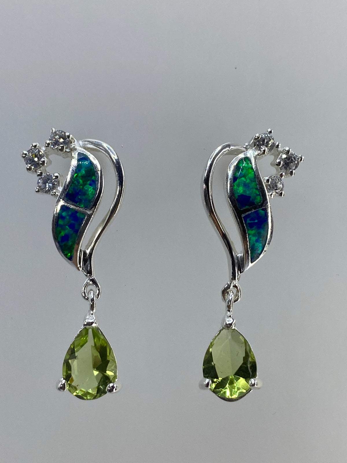 Par de aretes de plata con ópalo de fuego multicolor y circonia verde, vista frontal
