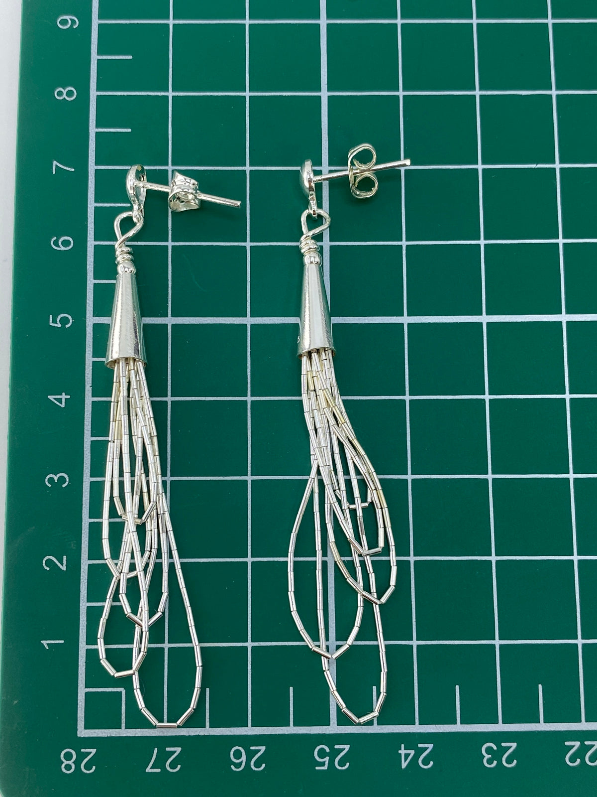Aretes colgando de poste con mariposa de plata, vista frontal de la cadena