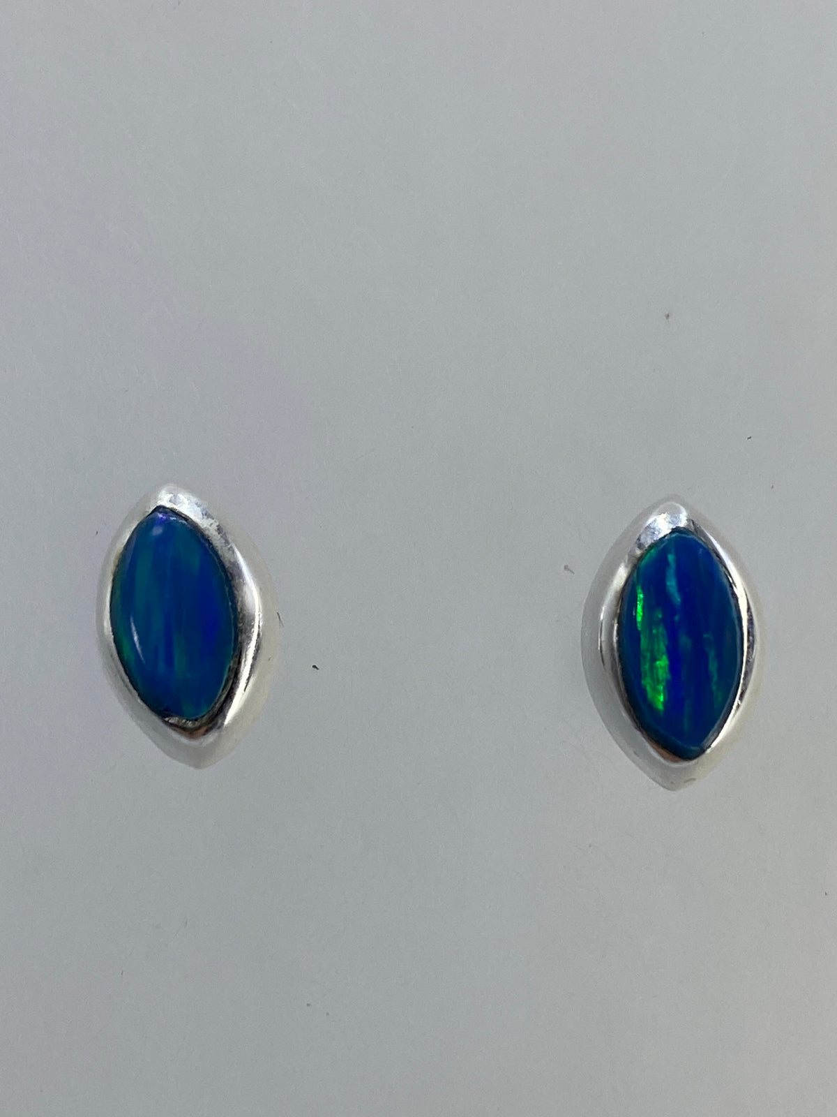 Aretes de ópalo fuego mostrando el juego de colores rojo, naranja y verde