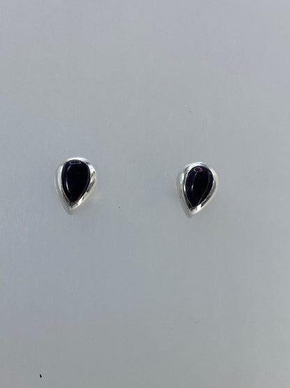 Detalle frontal de los aretes mostrando los reflejos de fuego del ópalo