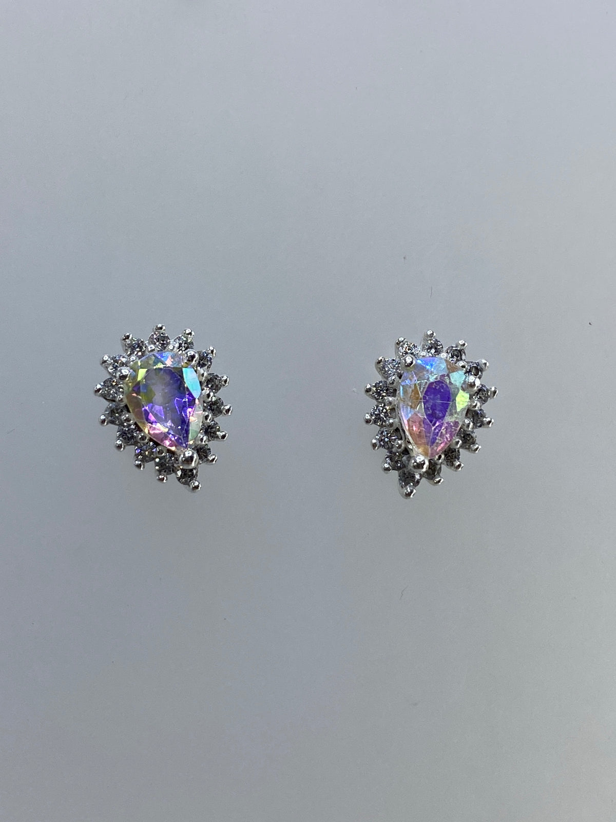 Detalle frontal de un arete mostrando el engaste de circonia multicolor rodeada de micro-cristales