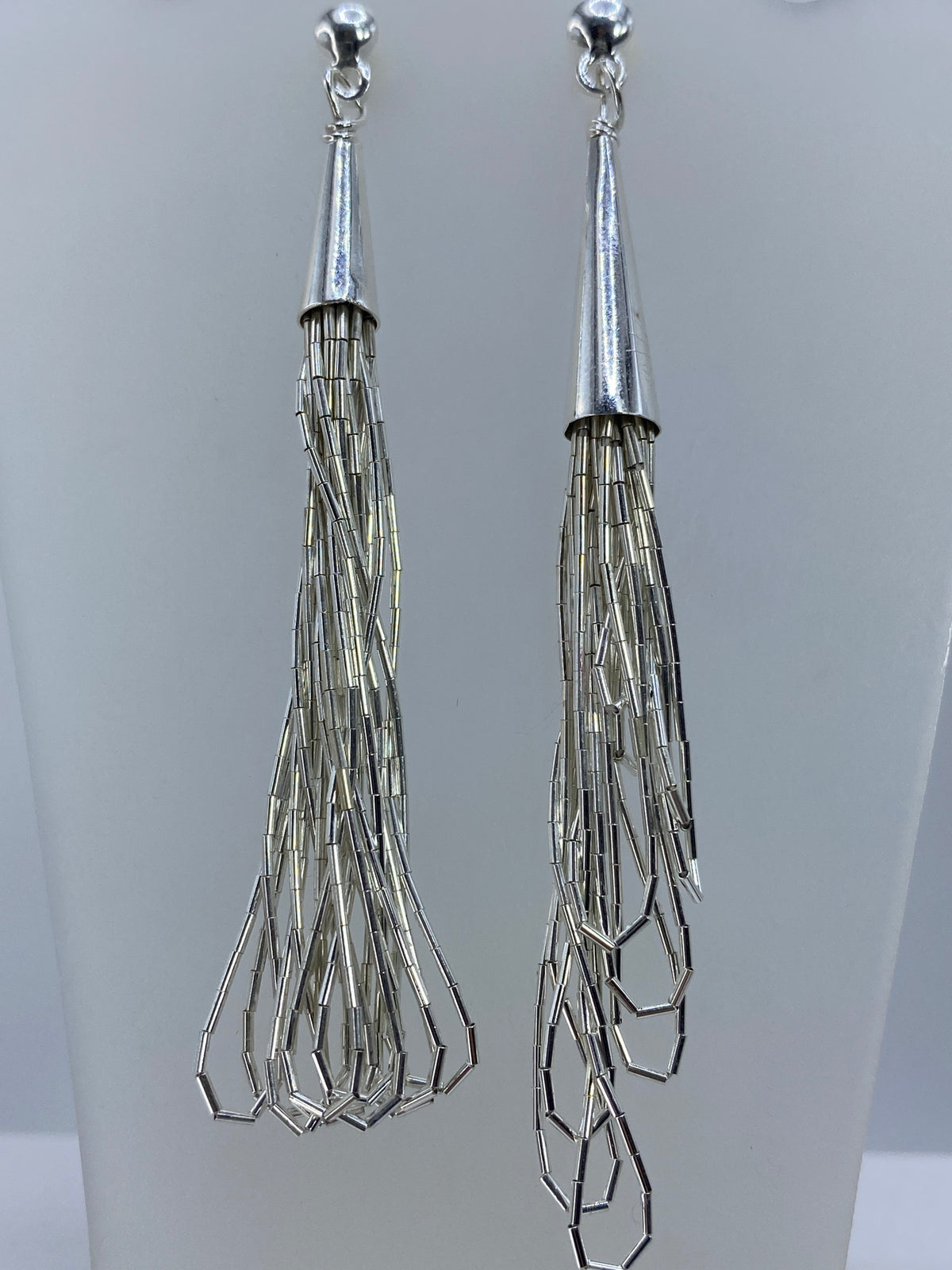 Detalle de los aretes mostrando las capas facetadas y el acabado pulido a brillo