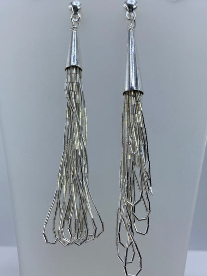 Detalle de los aretes mostrando las capas facetadas y el acabado pulido a brillo