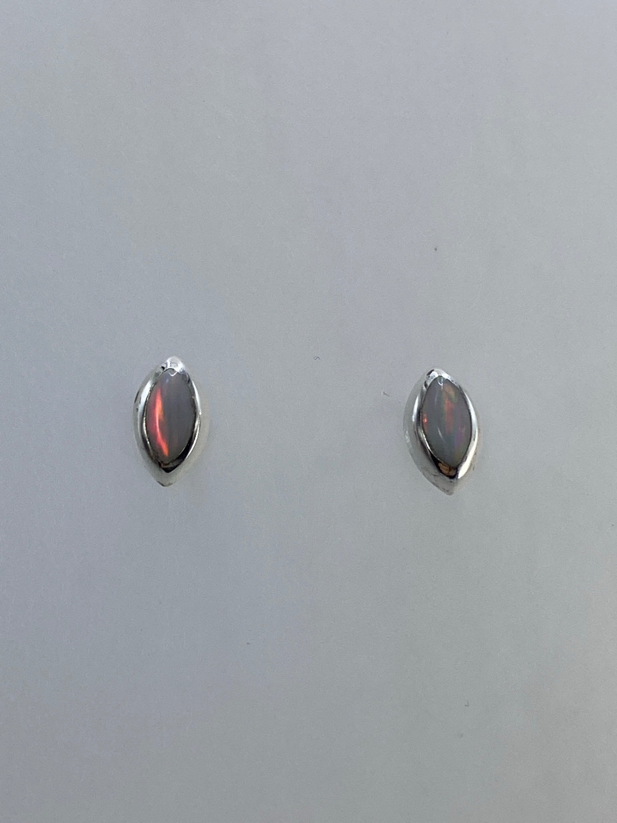 Aretes vistos de frente mostrando el brillo y juego de colores del ópalo de fuego
