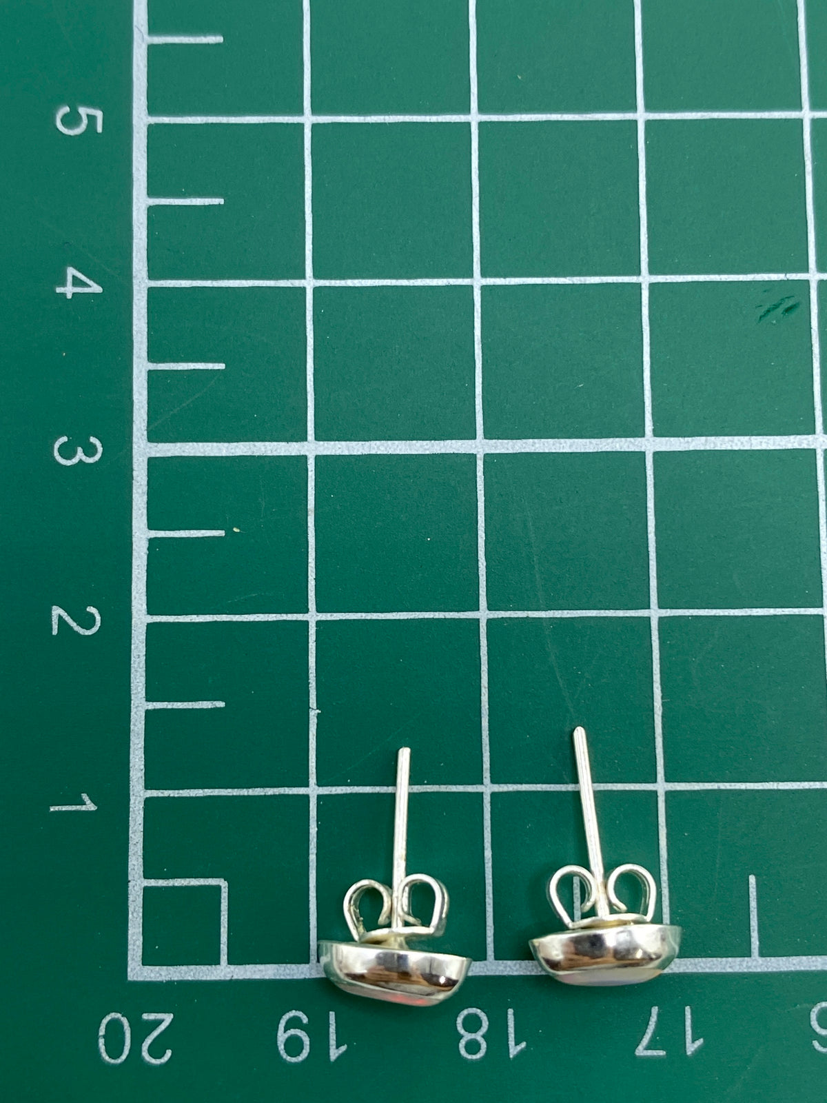 Aretes sobre escala de precisión mostrando peso de 0.65 g