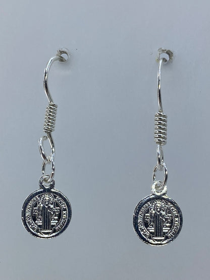 Detalle frontal de la medalla de San Benito con relieves repujados a mano en plata