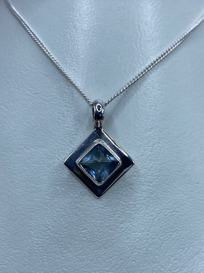 Dije de plata 925 con circonia azul cielo en diseno cuadrado doble marco