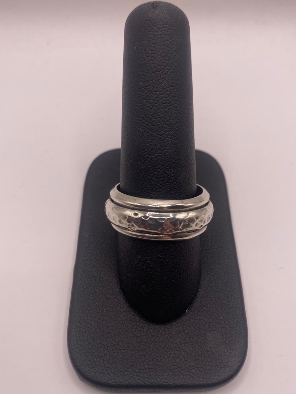Anillo spinner de plata .925 con textura martillada sobre fondo neutro — joyería artesanal antiestrés de Taxco