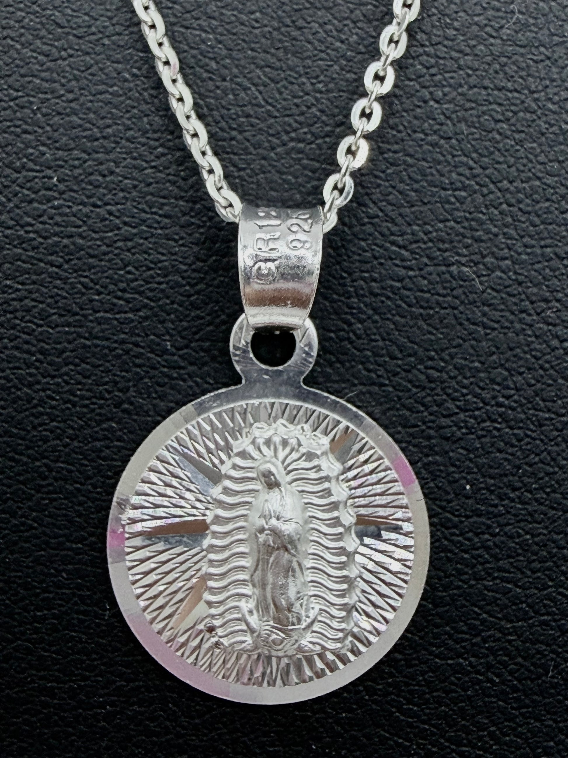 Detalle del dije religioso con relieve profundo de la Virgen de Guadalupe