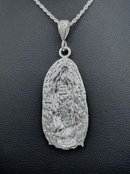 Detalle frontal del dije Virgen Guadalupe repujado con profundidad artesanal, relieve tallado en plata pura