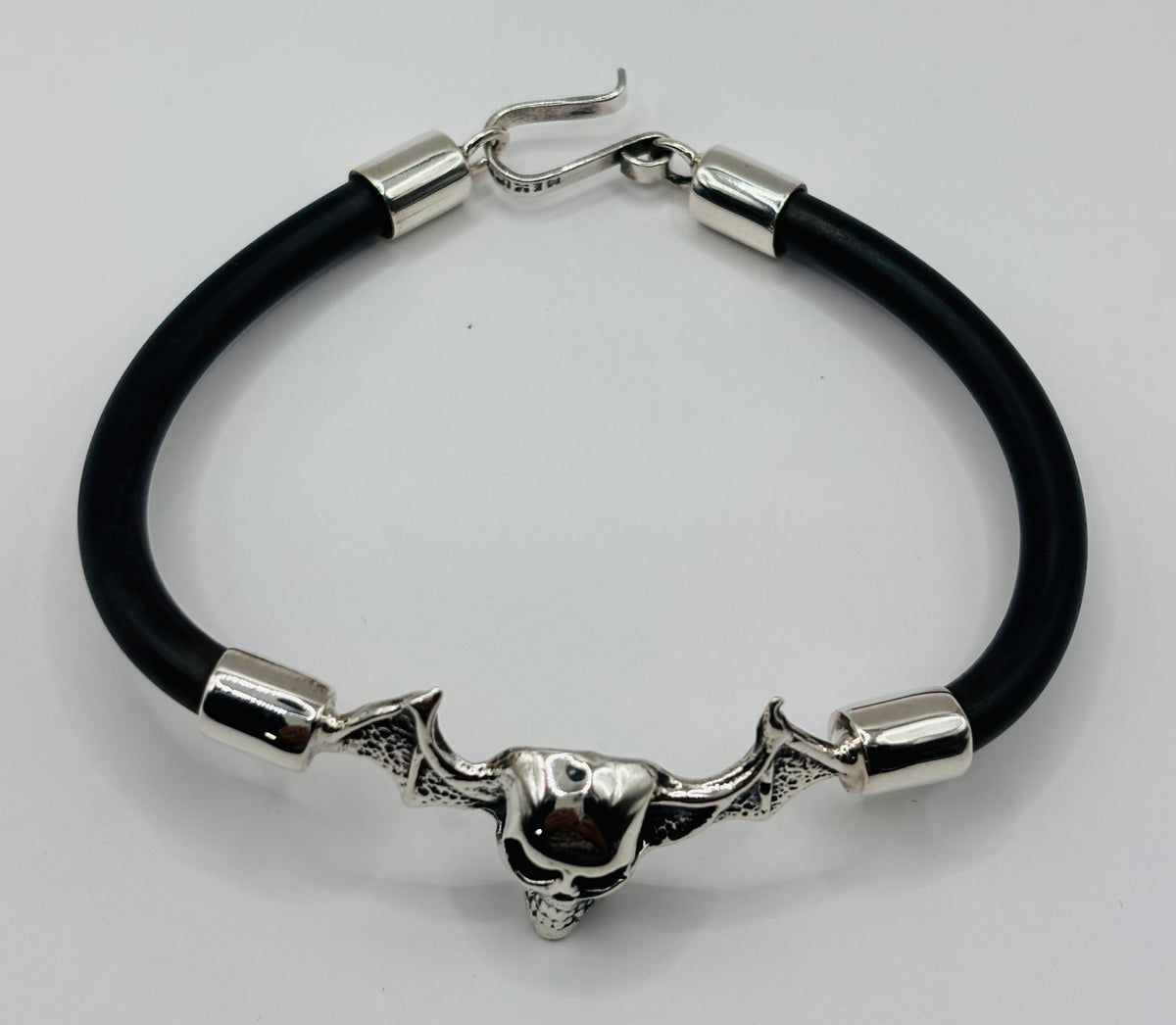 Vista lateral de pulsera calavera — cierre gancho seguridad en plata pulida