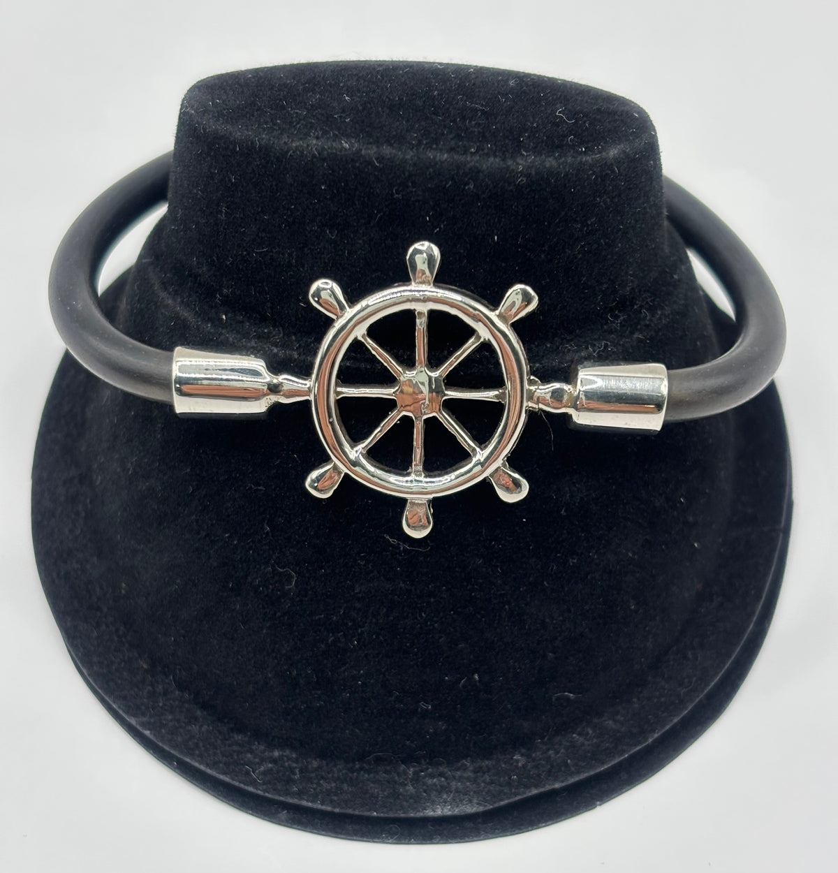 Pulsera timón náutico en plata .925 con cordón elástico negro, presentada en estuche de terciopelo