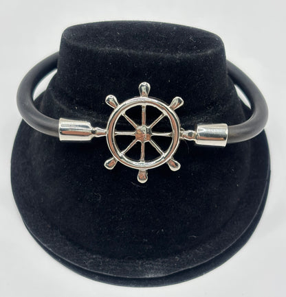 Pulsera timón náutico en plata .925 con cordón elástico negro, presentada en estuche de terciopelo