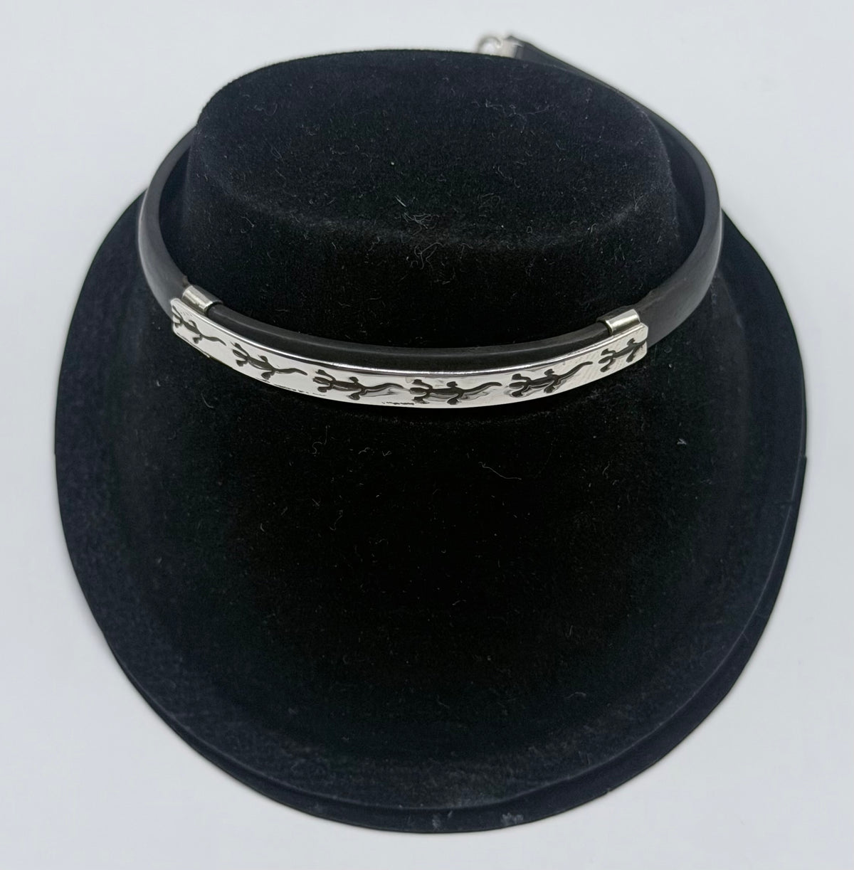 Pulsera de plata .925 y caucho negro con figura de iguana en cierre, vista frontal sobre maniquí